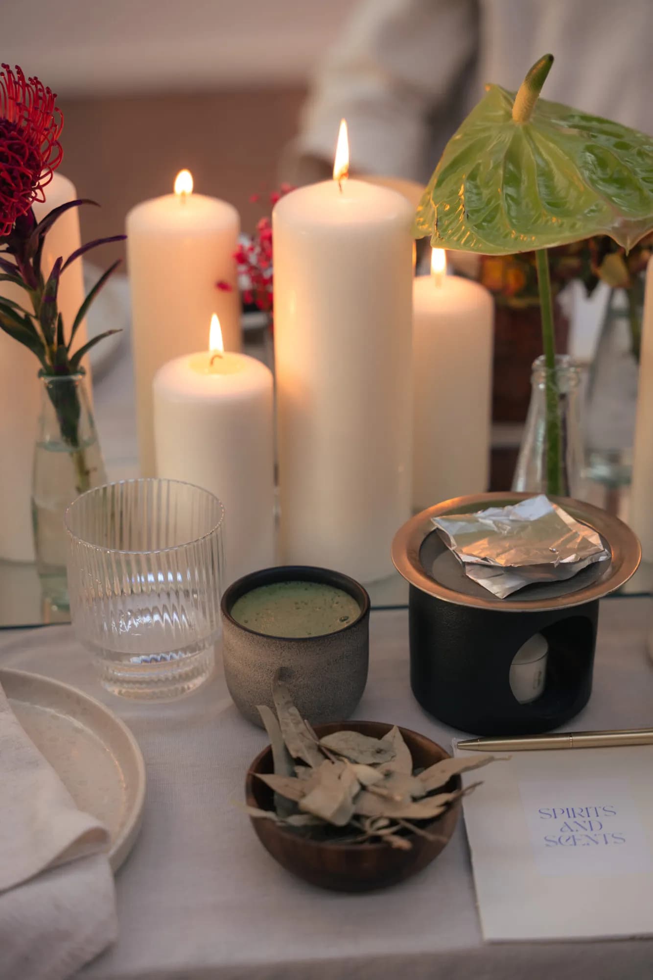 Kerzen, Blumen und Ritualschalen auf einem Tisch im Studio