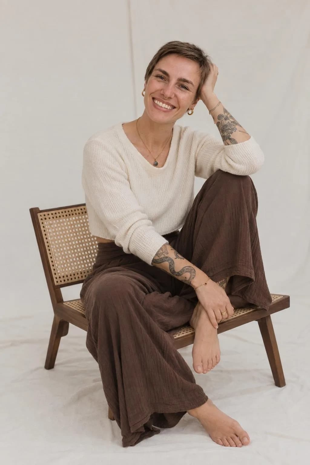 Hannah lachend auf einem Stuhl aus Holz und Wiener Geflecht