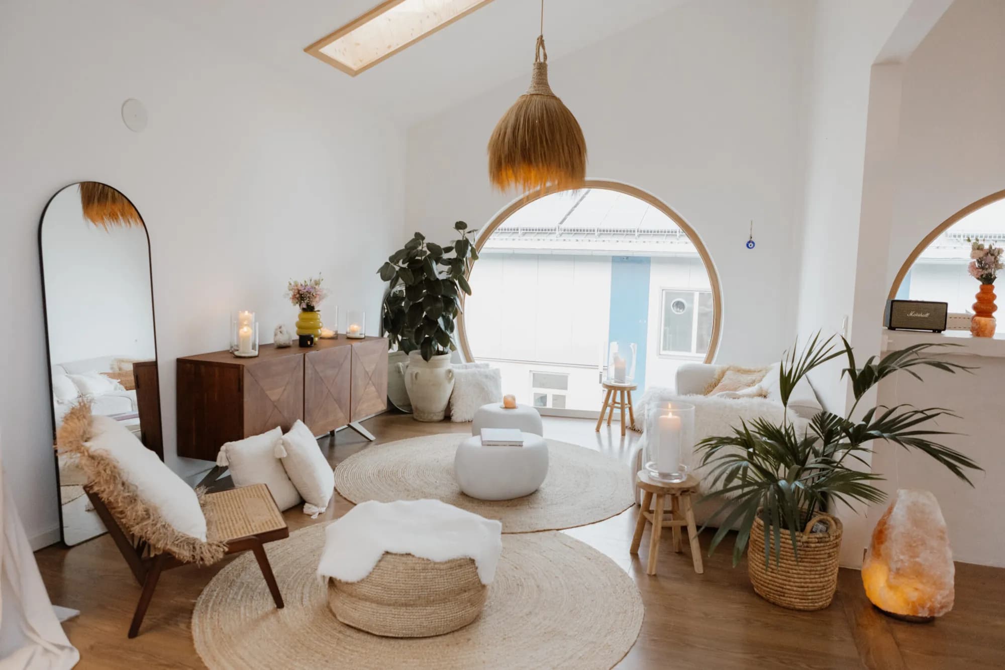 Lounge-Ecke im Studio La Soulis in Riedering mit Rundfenster, Sofa und Jutematten